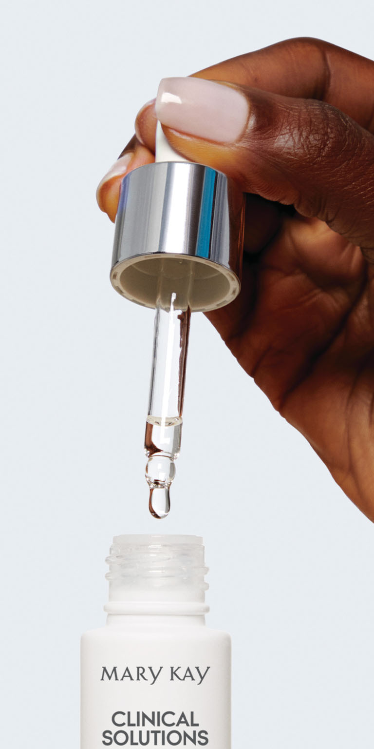 Model applying Mary Kay Clinical Solutions serum from dropper